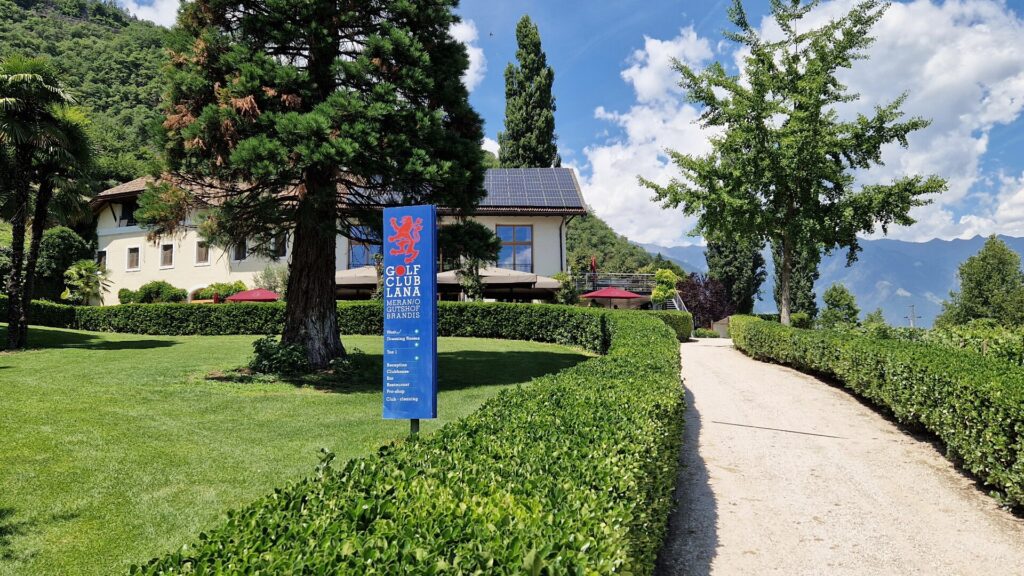 Clubhaus des Golfclubs Lana im Gutshof Brandis mit Weg und Hinweisschild 